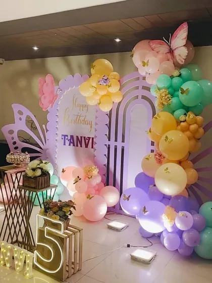 A side angle of the pastel butterfly party, showing the depth of the balloon garland and props.