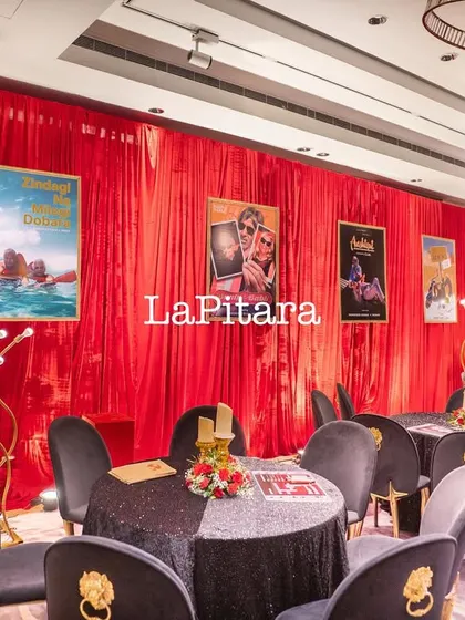 Another view of the chic Bollywood-themed dining setup, with modern gold floor lamps adding to the glamorous ambiance.