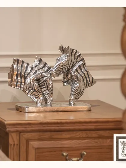 This silver and black zebra sculpture captures the beauty of wildlife in a modern, artistic form. It's a striking piece that adds a graphic and sophisticated touch to a side table.