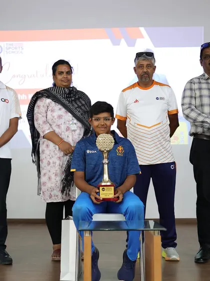 Tanshh Krishna with his family and coaches, holding his trophy. We celebrate our students' successes as a community.
