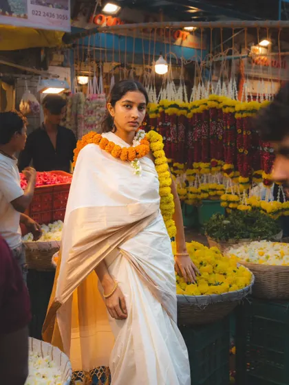 Surrounded by flowers, this shot feels both vibrant and serene. The composition places the model right in the heart of the market's beauty.