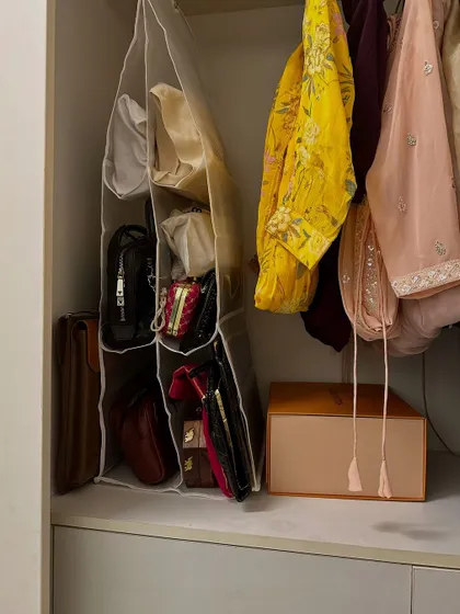 A hanging bag organizer is perfect for keeping purses and clutches visible and protected. This simple addition utilizes vertical space and prevents bags from losing their shape.