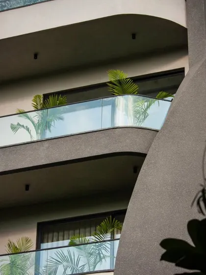 This detail shot of the Lotus Villa shows the fluid lines of the balconies against the textured concrete. The design adds greenery to soften the form and create a connection with nature.