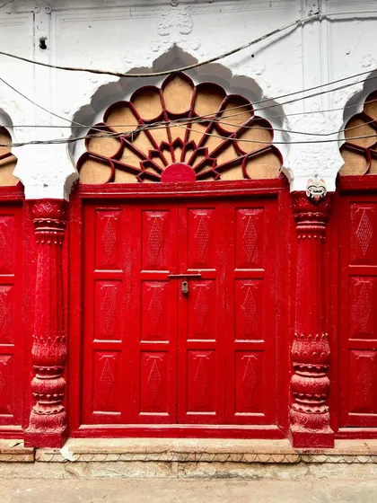 A striking red door provides a pop of color amidst the old lanes. The doors of Old Delhi are a highlight of our photo walks, each with its own character and story.