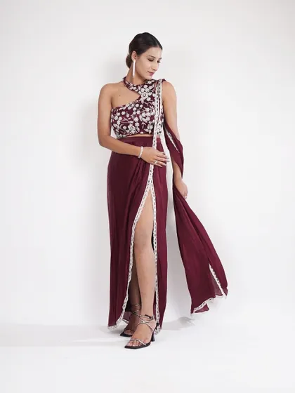 This wine-colored draped skirt with a one-shoulder embroidered top is the perfect mix of modern and traditional. The thigh-high slit adds just the right amount of drama.
