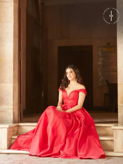 Channel your inner Jessica Rabbit in this alluring red gown. The off-shoulder neckline and dramatic full skirt are pure Hollywood glamour, available for you to rent.