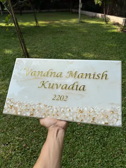 A clean and classic design, this white marble-themed nameplate is bordered with natural clear quartz crystals and gold-plated chips. The simplicity of the design allows the beauty of the materials to shine through.