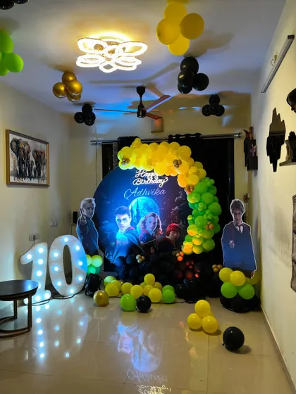 Bring the magic of Hogwarts to your party with my Harry Potter theme. This setup includes a themed backdrop, character cutouts, house-colored balloons, and a large marquee number '10'.