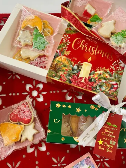 An assortment of our Christmas cookie gift packaging. We offer various options, from large boxes to smaller, individually wrapped packets, to suit any budget or occasion.