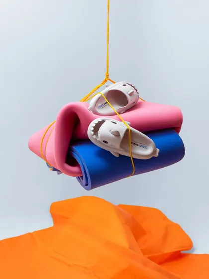 A playful, conceptual shot featuring kids' shark sliders suspended with yoga mats. The bright colors and creative composition make for a fun and memorable image.