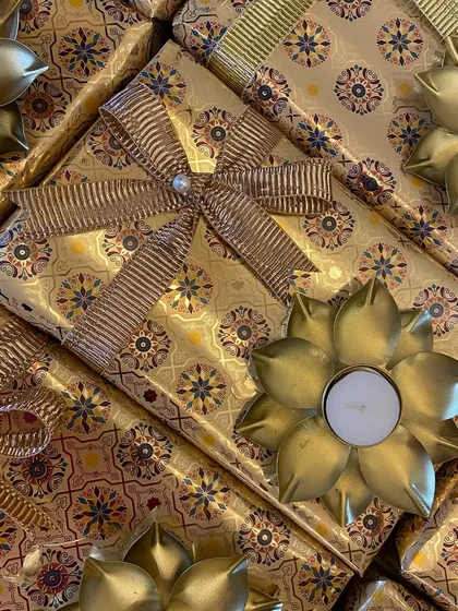 A close-up of the intricate golden wrapping paper and ribbon detail on our corporate Diwali boxes.