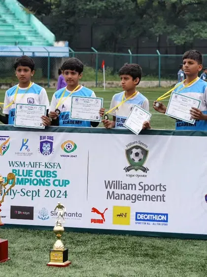 Our players standing proudly with their certificates and trophies at the WSM-AIFF-KSFA Blue Cubs Champions Cup. We ensure every participant is recognized for their contribution.