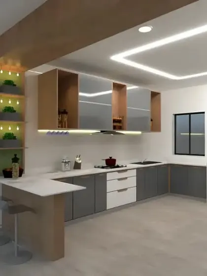 An L-shaped kitchen with a small breakfast counter extension. The design mixes grey and white cabinets with wood accents and open, illuminated shelving.