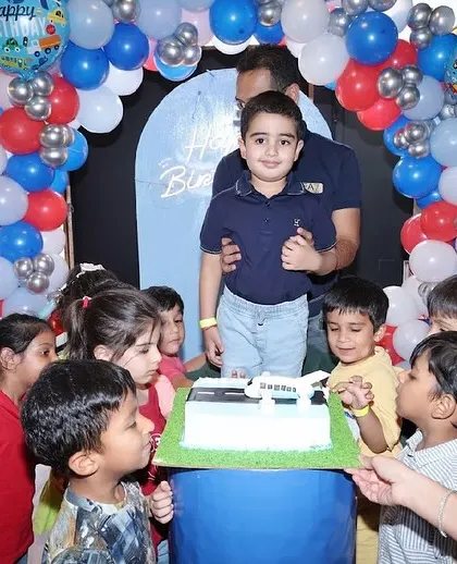 The birthday boy and his friends gather around the cake, excited for the celebration.