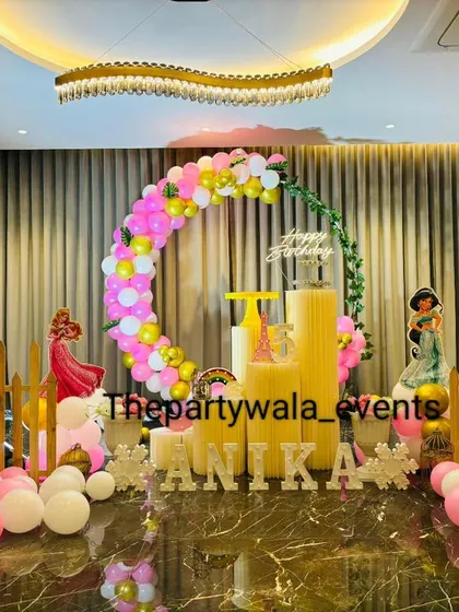A grand princess-themed setup in a beautiful venue. The pink and yellow balloon ring arch and character cutouts create a stunning focal point.