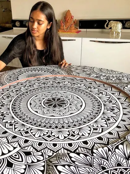 The practice of a mandala is about finding our place in the universe. A photo of me deep in thought while working on a large, layered piece.