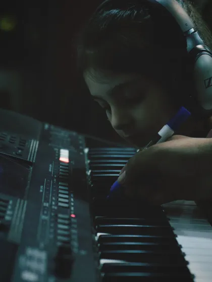 A teacher helps a young student mark notes on the keyboard. This hands on approach helps build a strong foundation.