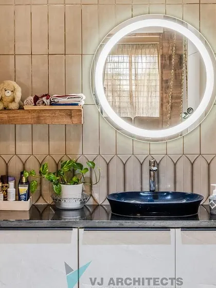 Even the bathroom vanity reflects the home's fusion theme. A modern, vessel-style sink in a bold blue is set against a backdrop of uniquely shaped tiles, complemented by a backlit circular mirror for a contemporary feel.
