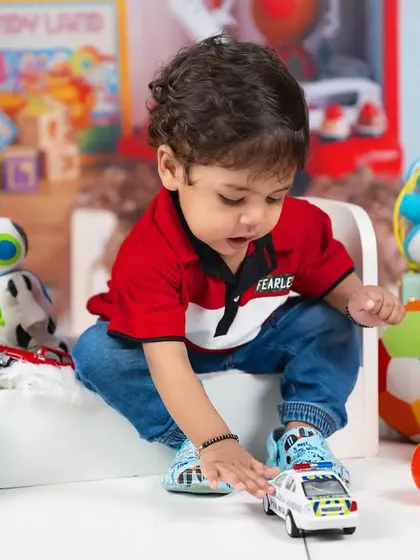 A candid shot of a toddler playing with his toys, capturing a genuine moment of childhood fun.