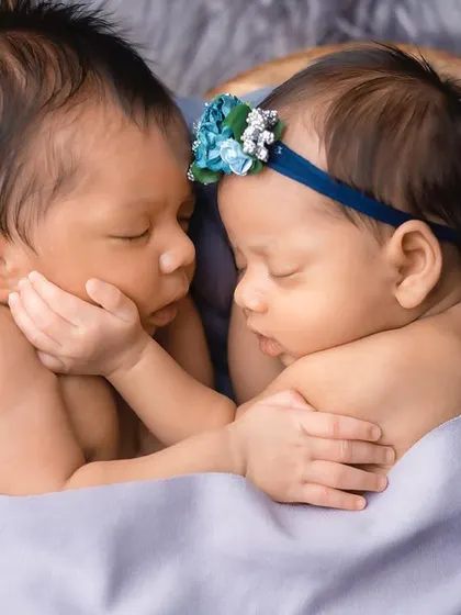 A close-up of the newborn twins, their faces close together as they sleep. This shot highlights their delicate features and the peacefulness of their bond.