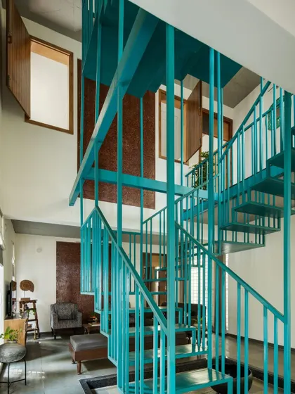 This angle highlights how the staircase interacts with the double-height space and the internal windows that look out from the bedrooms. This maintains a sense of connection and openness between private and common areas.