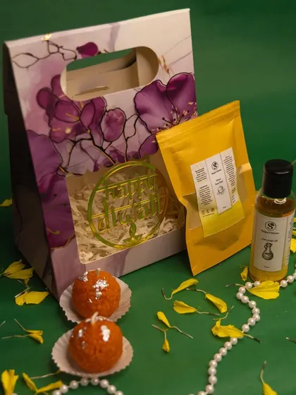 Our mini Diwali hamper is a delightful gift set. It includes two Ladoo-shaped candles, our natural Ubtan powder, and a bottle of Abhyanga oil, all packed in a convenient gift bag.