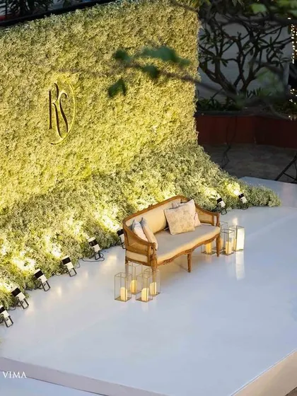 An ethereal all-white reception. The aisle and backdrop are adorned with clouds of baby's breath, while flickering candles cast a warm, romantic glow, creating a scene straight out of a fairy tale.