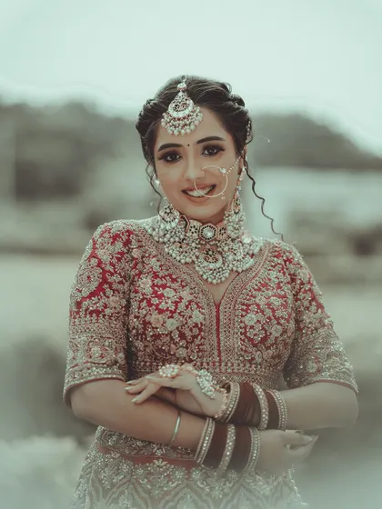 The joy of a bride shines through in her smile. This is a beautiful, candid-style portrait that captures her happiness and the exquisite details of her wedding jewelry and attire.