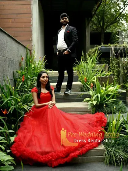 This photo shows the detail of the red ruffled gown. The man's classic black suit provides a perfect contrast, allowing the gown's texture and color to shine.
