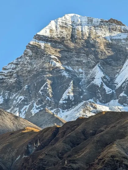 A close-up of a rugged, snow-dusted peak in the Himalayas, highlighting the raw, powerful beauty that we must work to preserve.