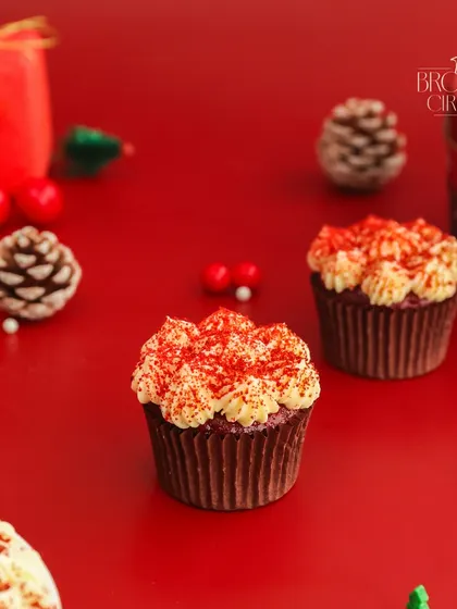 Our Red Velvet Cupcake gets a festive makeover for Christmas. The vibrant red crumb and white frosting look perfect against a holiday backdrop.