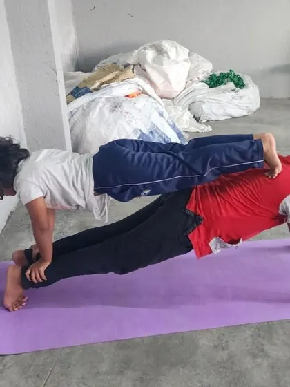 A strong double plank with the top partner's feet against the wall, demonstrating great body tension.