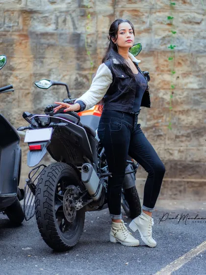 Adding a prop like a motorbike instantly injects a dose of attitude. This shot combines a tough biker aesthetic with a high-fashion pose, perfect for a bold portfolio.