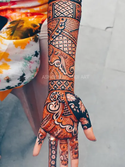 This design uses diagonal lines and a mix of bold, filled-in areas with delicate patterns to create a modern and dynamic look on the hand and arm.
