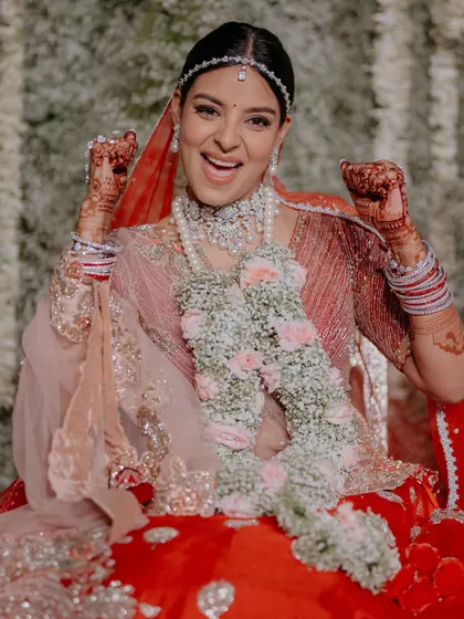 This bride is the picture of happiness. Her vibrant red lehenga is paired with a soft, glowing makeup look for her pheras.