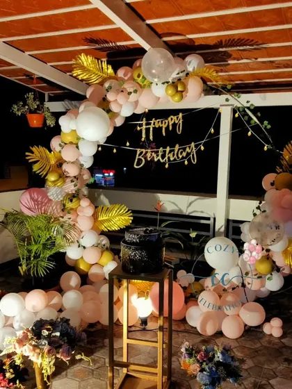 A beautiful balloon arch setup on a terrace, showing how I can decorate a balcony or rooftop space for a night-time celebration.