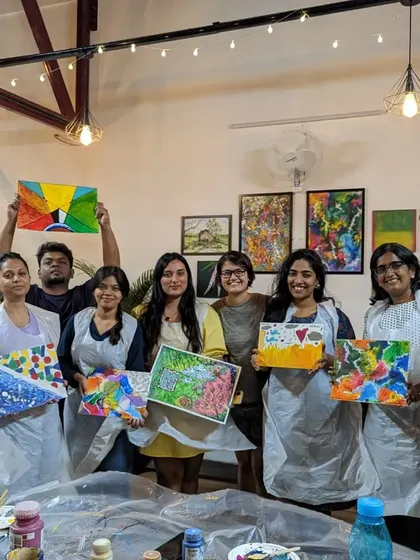 A group of proud participants with their finished abstract paintings. The diversity of styles and colors is a testament to their creativity.