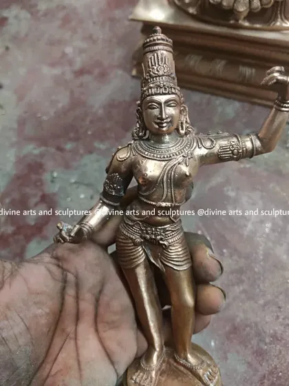 An artisan's hand holds a small, dynamic sculpture of Lord Rama in progress. This intimate view highlights the personal connection and care that goes into crafting even the smallest of our works.