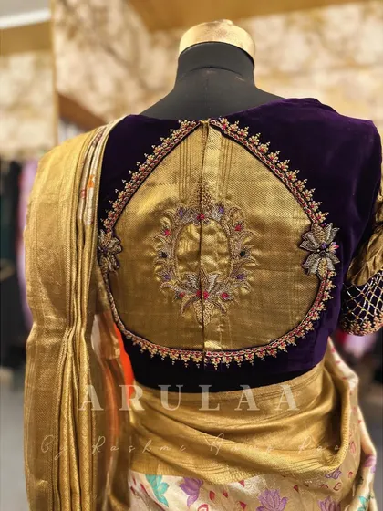 A stunning bridal blouse featuring a large, intricately embroidered motif on a gold tissue panel, framed by rich purple velvet. This is a true statement piece.