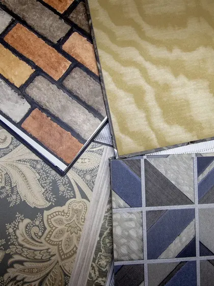 A collection of our wallpaper samples, showcasing a variety of textures and patterns from rustic brick and wood grain to elegant paisley and modern geometrics.