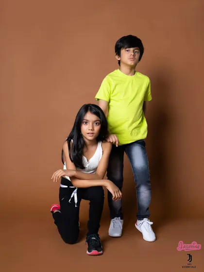 A studio shoot for a kids' fashion brand. The models' confident poses and the clean brown backdrop create a professional look for a commercial campaign.