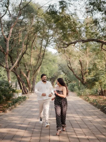 The couple enjoys a walk down a tree-lined path, a simple yet beautiful moment from their pre-wedding session.