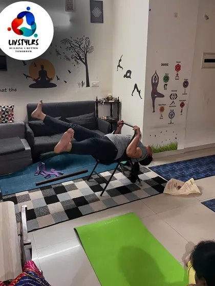 A client uses a yoga chair and staff for a challenging backbend and core exercise.