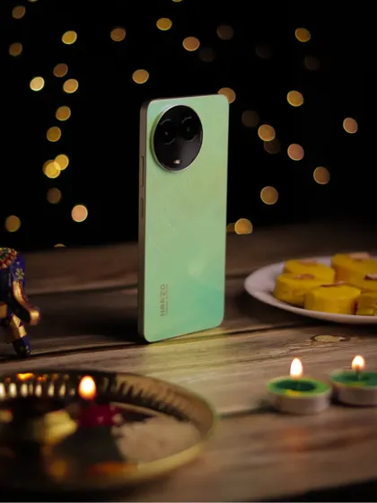 A close up of the realme C67 in a festive Diwali setting, with the focus on the phone amidst the warm glow of diyas.