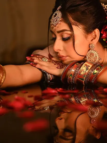 A dreamy bridal portrait with a reflection, surrounded by rose petals for a romantic and artistic feel.