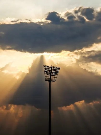 The story of a match begins before the players even take the field. This shot of the stadium floodlight against the evening sky captures the quiet anticipation and grand scale of a major sporting event.