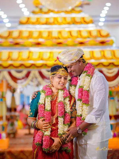 An intimate moment between the bride and groom during their wedding ceremony, surrounded by traditional decor.