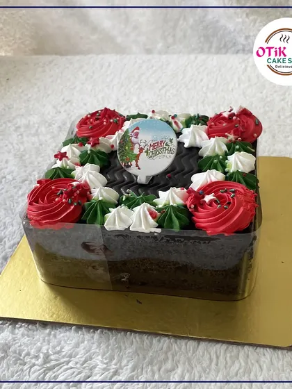 A square Christmas plum cake decorated with festive red and green buttercream rosettes. A beautiful and tasty addition to your holiday table.