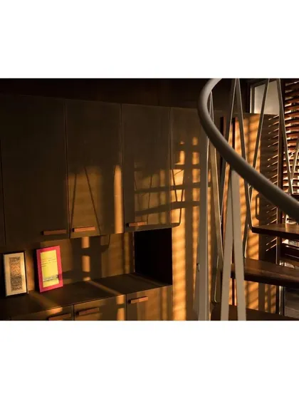 The shifting shadows cast by the twisting steel members of the spiral staircase create beautiful, dynamic patterns on the wooden cabinetry throughout the afternoon. This is an example of how I use architecture to engage with the daily passage of light.