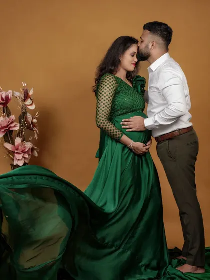 A tender moment between the couple. The flowing green satin of the maternity gown adds a beautiful sense of movement to the photograph.